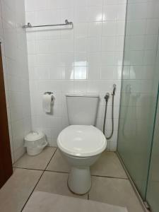 a white bathroom with a toilet and a shower at Hotel Palace Huesca in Presidente Prudente