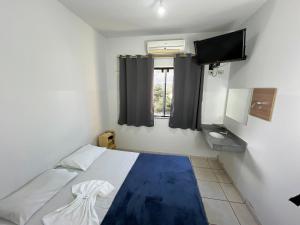 a small room with a bed and a television at Hotel Palace Huesca in Presidente Prudente