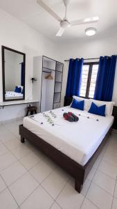 a bedroom with a large bed with blue curtains at Roche Kerlan Apartments in Anse Kerlan +34 photos