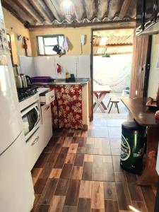 a kitchen with a refrigerator and a stove top oven at Hospedagem Jabuti no Centro de São Jorge in Sao Jorge