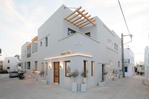 a white building with potted plants in front of it at Anapollo Boutique Hotel Adults Only in Naxos Chora