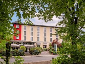 ein großes Gebäude mit rot-weißen in der Unterkunft Hotel Waldzeit Berlin-Grünau in Berlin