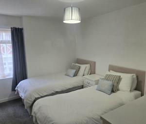 a bedroom with two beds and a couch at Riverside 2 in Dartmouth +8 photos
