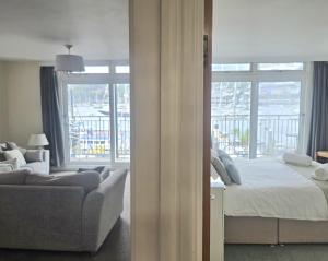 a bedroom with a bed and a couch and a window at Riverside 2 in Dartmouth