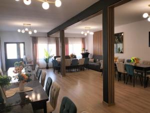 a living room with tables and chairs and a dining room at Cabana Ozon in Sărmaş +5 photos