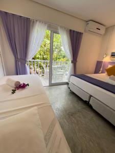 a hotel room with two beds and a balcony at Saint Germain Wind Residence in Icaraí
