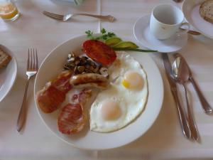 a plate of food with eggs and bacon on a table at Ambience Inn White River in White River