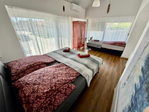 a bedroom with a bed and a large window at Ulics vendégház II in Zalacsány +76 photos