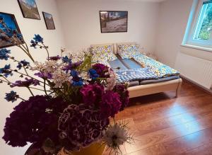 a bedroom with a bed with flowers in a vase at Ferienwohnung Glusavinahüsle in Vandans