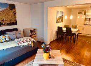 a living room with a bed and a dining room at Ferienwohnung Glusavinahüsle in Vandans