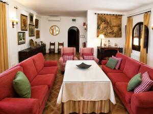 a living room with red couches and a table at Aromas del Raposo in Puebla de Sancho Pérez