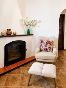 a living room with a chair and a fireplace at Aromas del Raposo in Puebla de Sancho Pérez
