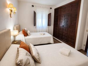 a room with two beds and a brown door at Aromas del Raposo in Puebla de Sancho Pérez +26 photos