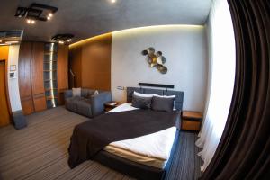 ein Zimmer mit einem Bett und einem Stuhl in der Unterkunft MOJO HALL Hotel in Luzk