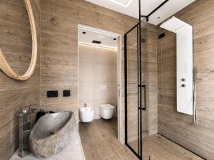 a bathroom with a shower with a tub and a sink at Agarthi Suites in Piateda