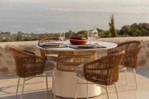 a table and chairs with wine glasses and a bowl of fruit at Eks Mani Peninsula Retreat in Pirgos