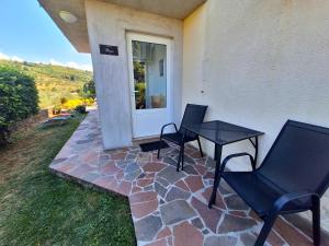a patio with two chairs and a table on a house at Apartment Burja with Olive Grove & Salt Pans View in Portorož