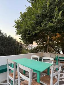 a green table and chairs sitting next to a wall at Kalloni Village House in Kalloní