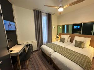 a hotel room with a bed and a desk at Dyke Hotel in Le Puy-en-Velay