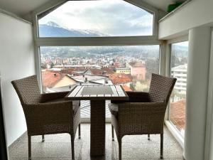 a table and two chairs in a room with a large window at Modern Penthouse with Unbeatable Panoramic Views in Peje