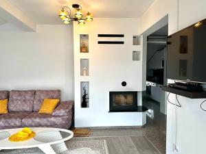 a living room with a couch and a fireplace at Modern Penthouse with Unbeatable Panoramic Views in Peje