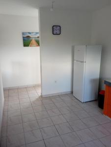 a room with a refrigerator and a clock on a wall at Tropical Orange House in Ducos