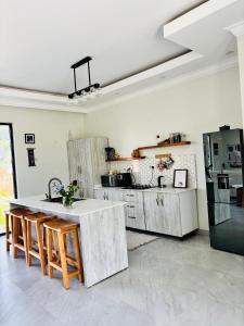 eine Küche mit einem Tisch und einem Kühlschrank in der Unterkunft Bougainvillea House in Mwaja