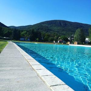 a swimming pool with blue water and mountains in the background at Chateau Franz in Osek
