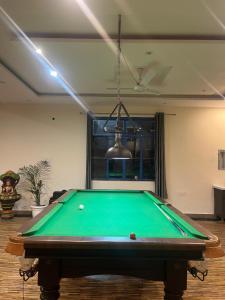 a green pool table in a room with a light at Moonshiva stay and cafe in Rishīkesh