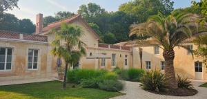 a house with two palm trees in front of it at Logis de l'Héronière in Salles-sur-Mer