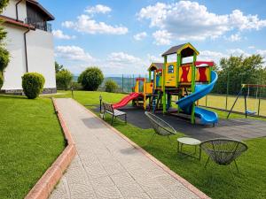 a playground with a slide and chairs in the grass at Park Hotel Arbanassi in Arbanasi