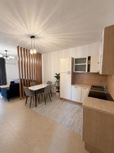 a kitchen and living room with a table and chairs at Ayzal Apartment in Shëngjin