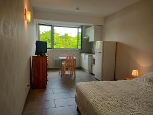 a bedroom with a bed and a kitchen with a table at Locaplage in Lanton