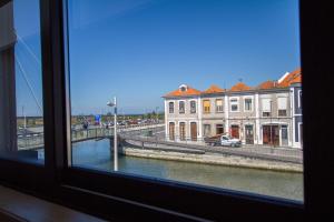 une fenêtre avec vue sur la rivière et les bâtiments dans l'établissement Casa dos Mercanteis, à Aveiro