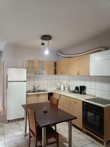 a kitchen with a table and a white refrigerator at LA.KI House in Kavála