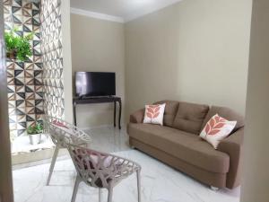 a living room with a couch and a chair at Casa das Petúnias in Ubajara