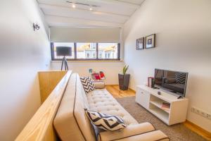 a living room with a couch and a tv at Casa dos Mercanteis in Aveiro