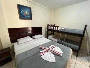 a bedroom with a bed and two bunk beds at Pousada dos Pássaros Pipa in Pipa