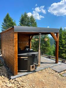 a barbecue grill in a wooden shed at Crow`s Nest Murmur Măguri in Măguri