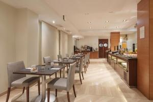 a restaurant with long tables and chairs and a counter at Dorma León in León