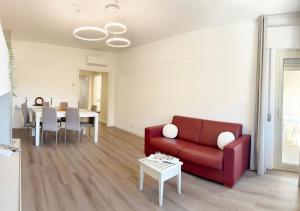 a living room with a red couch and a table at Holihome - LUNA in Tortoreto Lido
