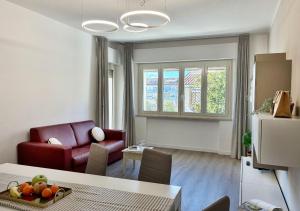 a living room with a table and a red chair at Holihome - LUNA in Tortoreto Lido +45 photos