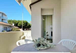 a table with a bowl of flowers on a balcony at Holihome - LUNA in Tortoreto Lido