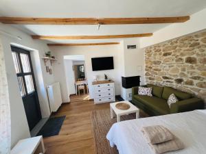 a living room with a green couch and a stone wall at Nevoliani stone house in Florina