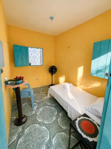 a bedroom with a bed and a table and a window at Residencial dos Freitas in Jericoacoara