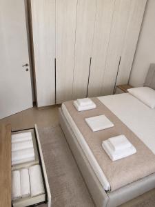 a bedroom with a bed with two towels on it at Ayzal Apartment in Shëngjin
