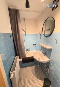 a blue tiled bathroom with a sink and a tub at BEGE APARTMENTS Business Studio in Hagen +17 photos