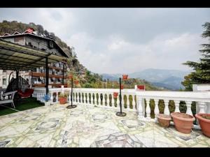 a balcony of a house with a view of a mountain at Tara Regency Hotel in Shimla +6 photos