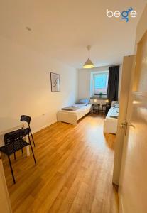 a room with two beds and a table and chairs at BEGE APARTMENTS Business Studio in Hagen