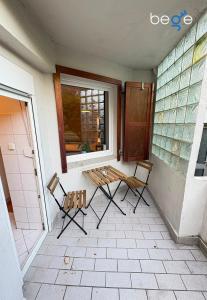 two chairs and a bench on a porch with a window at BEGE APARTMENTS Business Studio in Hagen